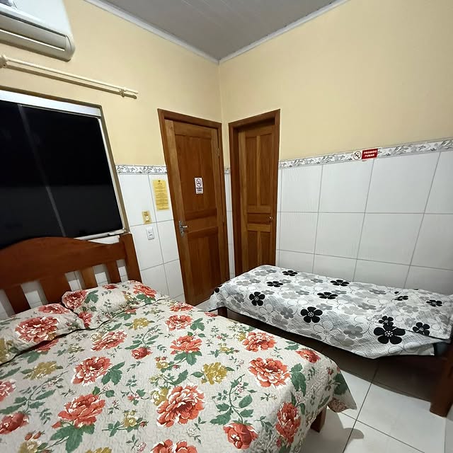 Quarto familiar do Hotel Grão Pará com TV e duas camas